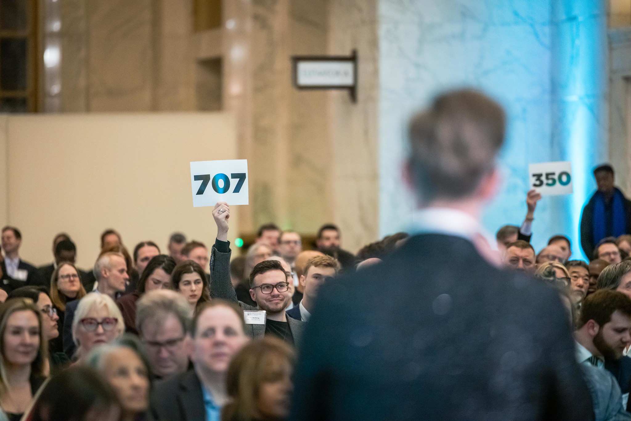 A gala guest raising a paddle during a live fundraising appeal